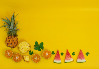Fototapeta na wymiar exotic tropical fruits, pineapple, orange, watermelon isolated on a yellow background