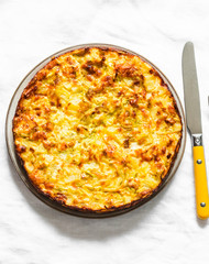 Leeks, potatoes, zucchini tortilla on a light background, top view. Delicious appetizer, tapas, breakfast