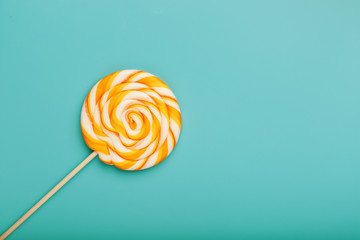 Colorful round Lollipop, on mint blue background. Minimal concept with copy space.