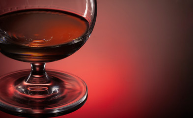 Glass of whiskey or cognac on black background with space for text on black background
