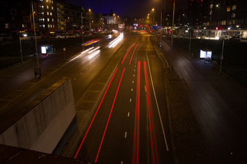 Fototapeta na wymiar Intersection at night with traffic lights and traffic blurred by motion in Arnhem, Netherlands