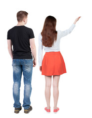 Back view of a stylish couple pointing.