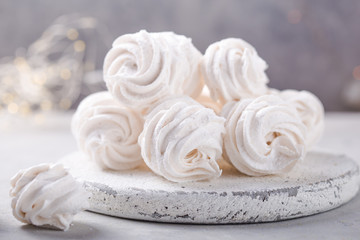 White zephyr on grey concrete background. Set of homemade marshmallow Meringue, pansy. Russian sweetness cusine