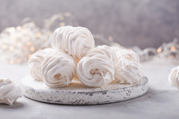 Obraz na płótnie Canvas White zephyr on grey concrete background. Set of homemade marshmallow Meringue, pansy. Russian sweetness cusine