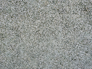 Wall made of small grains in white, black and grey colors that can be found on the buildings in the outdoors with rough texture and cool wallpaper