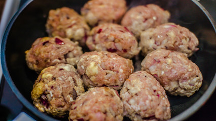 Lots of non-fried chops in a frying pan.