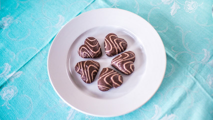Christmas gingerbread in the form of hearts on a white plate and a blue tablecloth
