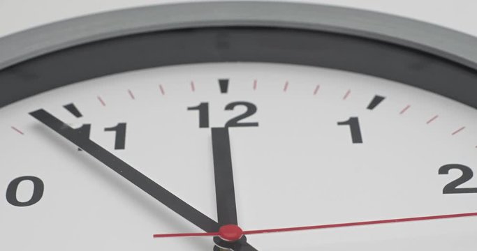 Truck shot of time-lapse gray clock with black arrows shows motion the time speed up from 11.00 and slow down to 12.00, How time flies concept.