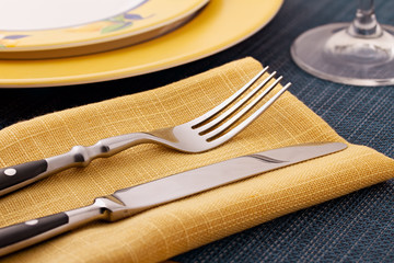 serving knife and fork on a yellow napkin