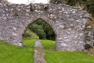 wideshot Stone wall, arch over path