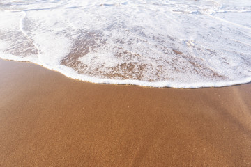 Soft sea Wave On Sandy Beach. Summer and vacations and travel concept. Selective focus, with copy space .