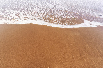 Soft sea Wave On Sandy Beach. Summer and vacations and travel concept. Selective focus, with copy space .