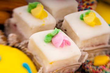 Bakery display closeup of iced petit fours small cakes
