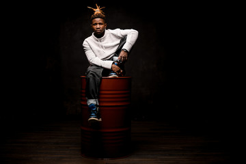 Afro american guy sitting on a barrel