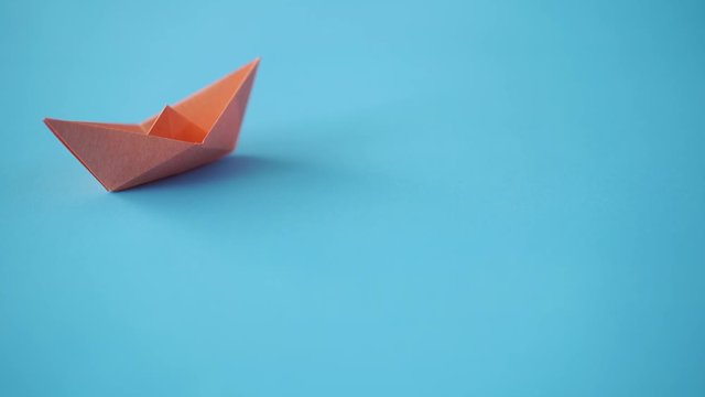 paper boat on clean blue background with copy space, lesson and education concept