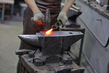 Forging an iron handmade product in a craft forge workshop
