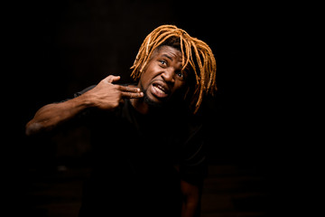 Afro american guy points with fingers at his jaw