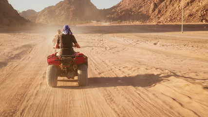 Quad bike ride through the desert near Sharm el Sheikh, Egypt.Adventures of desert off-road on ATV.Sand and Sand Borkhan. Rock and sunset. Quad Cycle Travel. Excursion with people. © Yaroslav