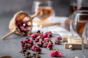 tea made from tea rose petals in a glass bowl on drak black rustic background
