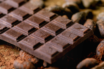 Dark chocolate bar with cocoa beans, cocoa powder. Food background. Close up