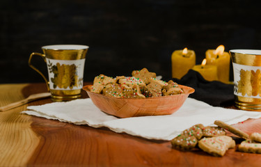 Plate and cups with delicious ginger cookies, cinnamon, chocolate, vanilla, on the table, closeup view Christmas