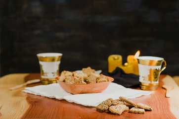 Plate and cups with delicious ginger cookies, cinnamon, chocolate, vanilla, on the table, closeup view Christmas