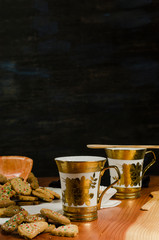 Plate and cups with delicious ginger cookies, cinnamon, chocolate, vanilla, on the table, closeup view Christmas