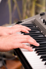 Obraz premium hands pressing keys while playing the electronic piano.