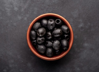 black olives in a thicket on a stone background.