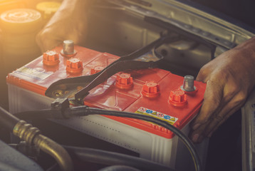 A car mechanic replaces a battery