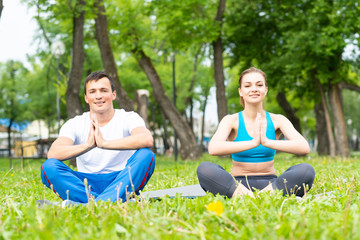 Young couple doing yoga in park together