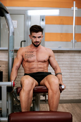 Shirtless muscular young man doing do leg exercises © VisionPro