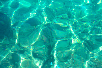 Background made of clean blue water sea surface. Mediterranian surface on sunny day with waves and flares. Copy space.