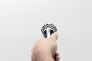Hand holding a microphone isolated on white background.