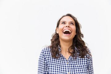 Joyful excited student girl laughing at joke. Young woman in casual checked shirt standing isolated over white background. Healthy teeth concept