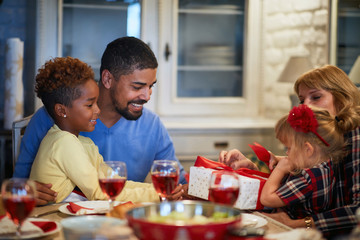 family opening Christmas presents at table