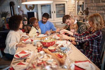 Fototapeta na wymiar Happy families enjoying Christmas dinner