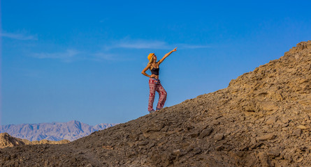 tourism wallpaper pattern photography with empty space for copy or text of posing girl go forward on desert sand stone mountains on blue sky background  