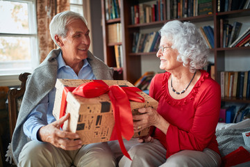 Elder couple exchanging Christmas gifts