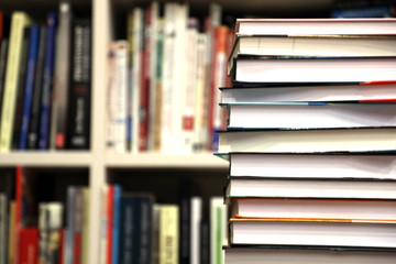stack of books on bookshelf background, promotion of reading books