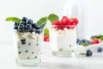 Cottage cheese with cream, raspberry and blueberry garnished with fresh mint.