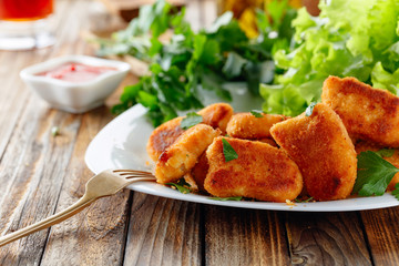 Fried chicken nuggets with ketchup sprinkled with chopped parsley.
