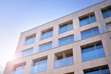 Fototapeta premium Modern apartment buildings on a sunny day with a blue sky. Facade of a modern apartment building. Glass surface with sunlight.