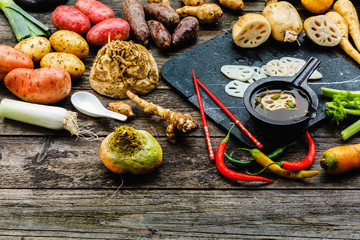 Asian lotus root began to be used in world kitchens. Slicies on old black stone deck on old wooden background, Miso Soup with Winter Vegetables