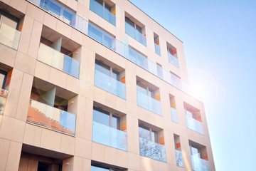 Modern apartment buildings on a sunny day with a blue sky. Facade of a modern apartment building. Glass surface with sunlight.