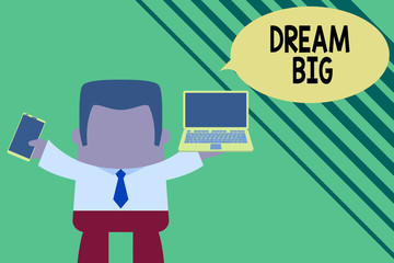 Conceptual hand writing showing Dream Big. Concept meaning seeking purpose for your life and becoming fulfilled in process Professional man holding laptop in left mobile phone right