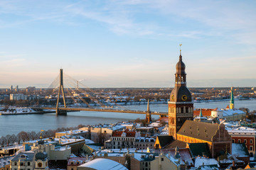 Aerial panoramic view of Riga old town, clock tower, Daugava river and modern bridge. Winter sunny day.