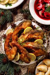 Christmas carp, Fried carp fish slices on a ceramic plate on the holiday table, top view. Traditional christmas eve dish. Polish Christmas