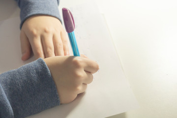  girl writes a letter in pencil in a notebook