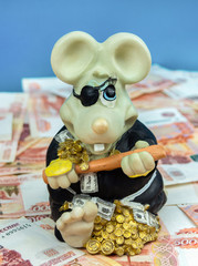 The piggy Bank rat is sitting on money.The symbol of the New year